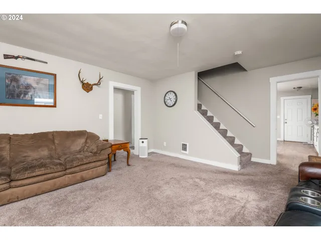 a living room with furniture and stairs