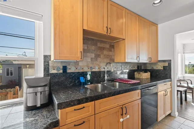 a kitchen with granite countertop a sink a stove and cabinets