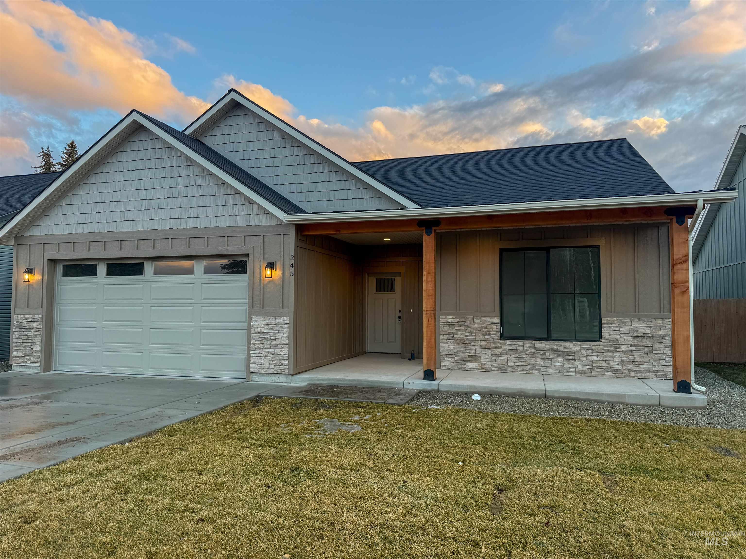 View of front of house with stone siding, board and batten siding, a front lawn, and a porch