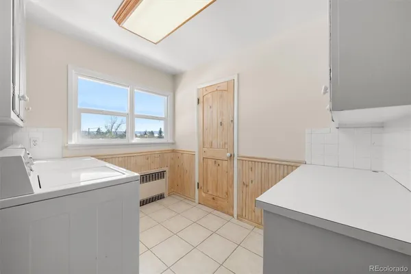 a utility room with cabinets washer and dryer
