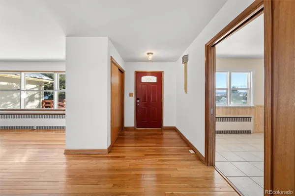 a view of a hallway with wooden floor and windows