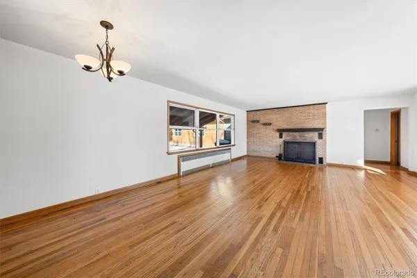 a view of empty room with wooden floor and window