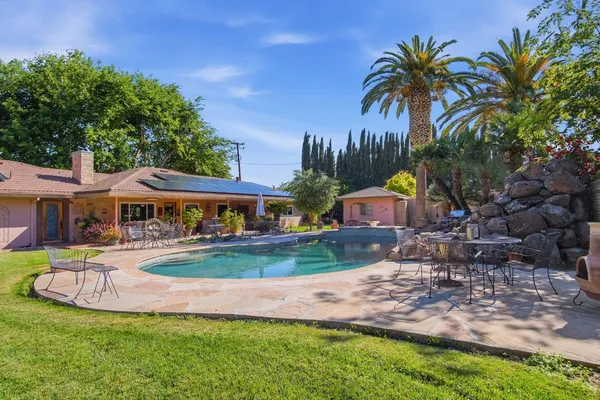 a dining room with wooden floor a chandelier fan a wooden floor and a chandelier