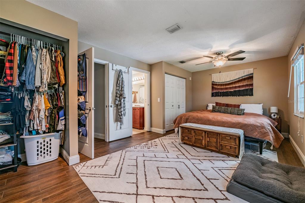611 St Henry Drive Brandon, FL 33511 - Photo 15 of 34 a spacious bedroom with a large bed a flat screen tv and a bookshelf
