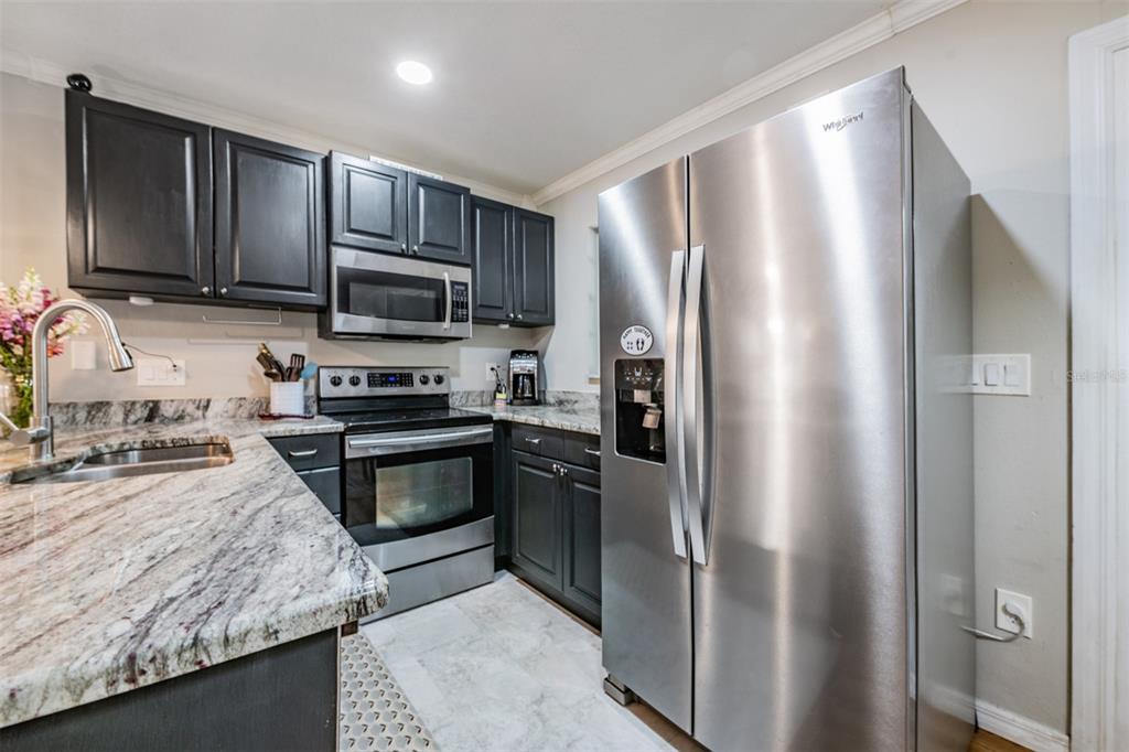 611 St Henry Drive Brandon, FL 33511 - Photo 10 of 34 a kitchen with granite countertop stainless steel appliances and wooden cabinets