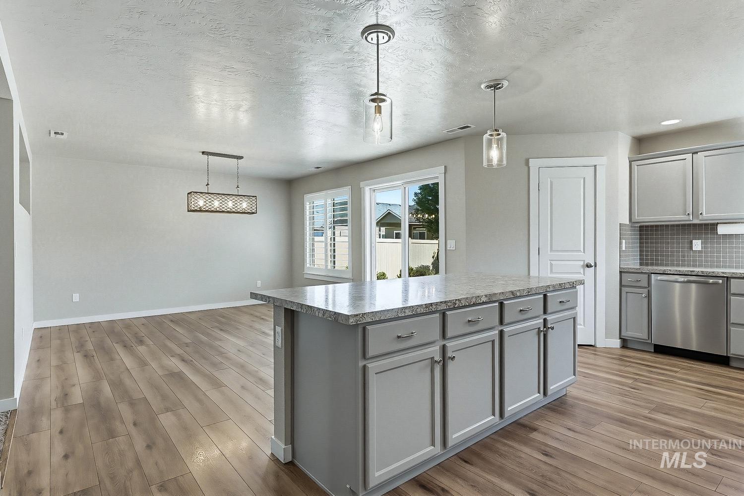 846 North Hidden View Way Star, ID 83669 - Photo 13 of 49 Central kitchen island with gray cabinetry and stone-look countertop