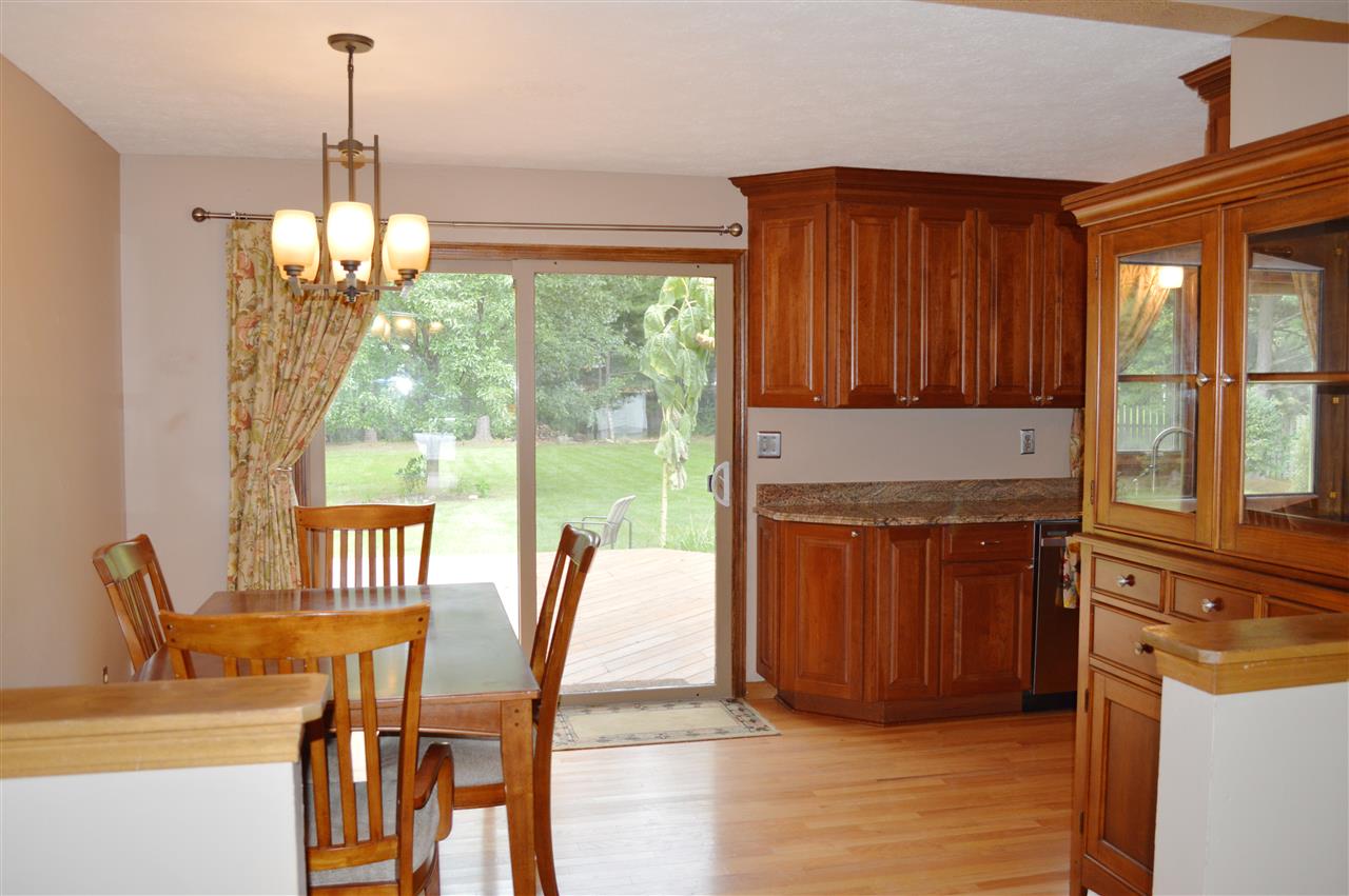 5642 Gray Eagle Road Roscoe, IL 61073 - Photo 4 of 15 a view of a dining room with furniture a chandelier and wooden floor
