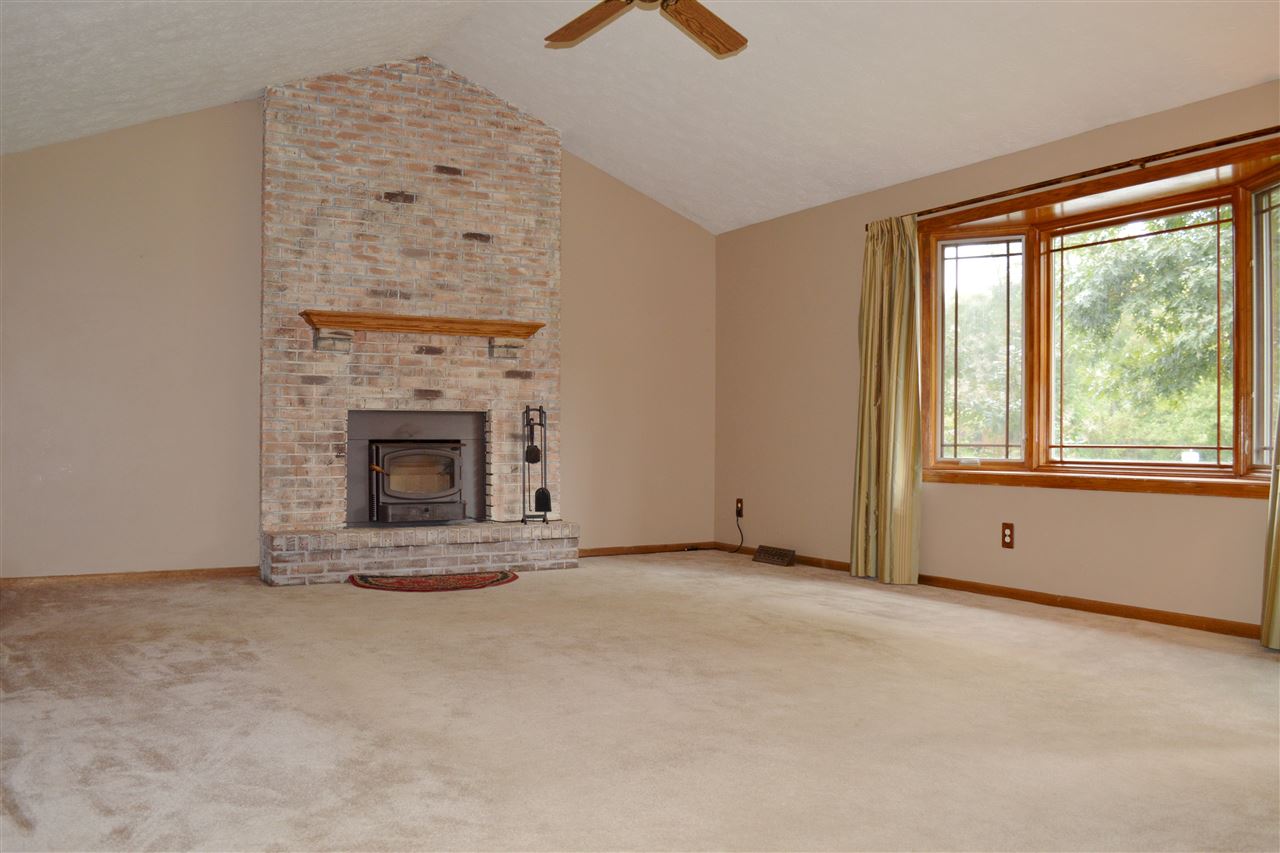 5642 Gray Eagle Road Roscoe, IL 61073 - Photo 5 of 15 an empty room with furniture and a fireplace