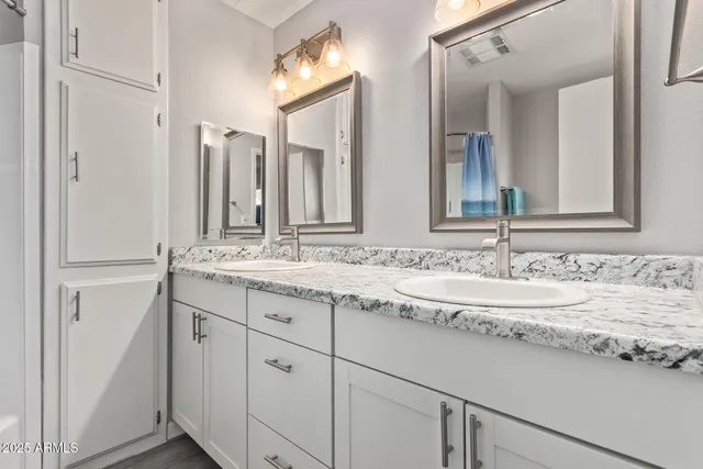 a bathroom with a granite countertop sink and a mirror