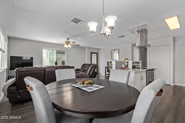 a living room with furniture a dining table and a chandelier