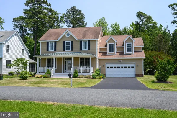 a front view of a house with a yard and potted plants
