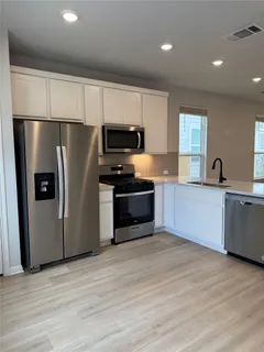a kitchen with stainless steel appliances a refrigerator sink and microwave