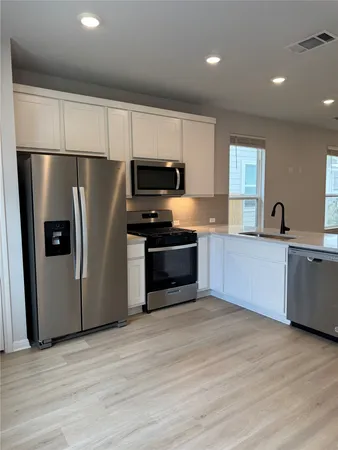 a kitchen with stainless steel appliances a refrigerator sink and microwave