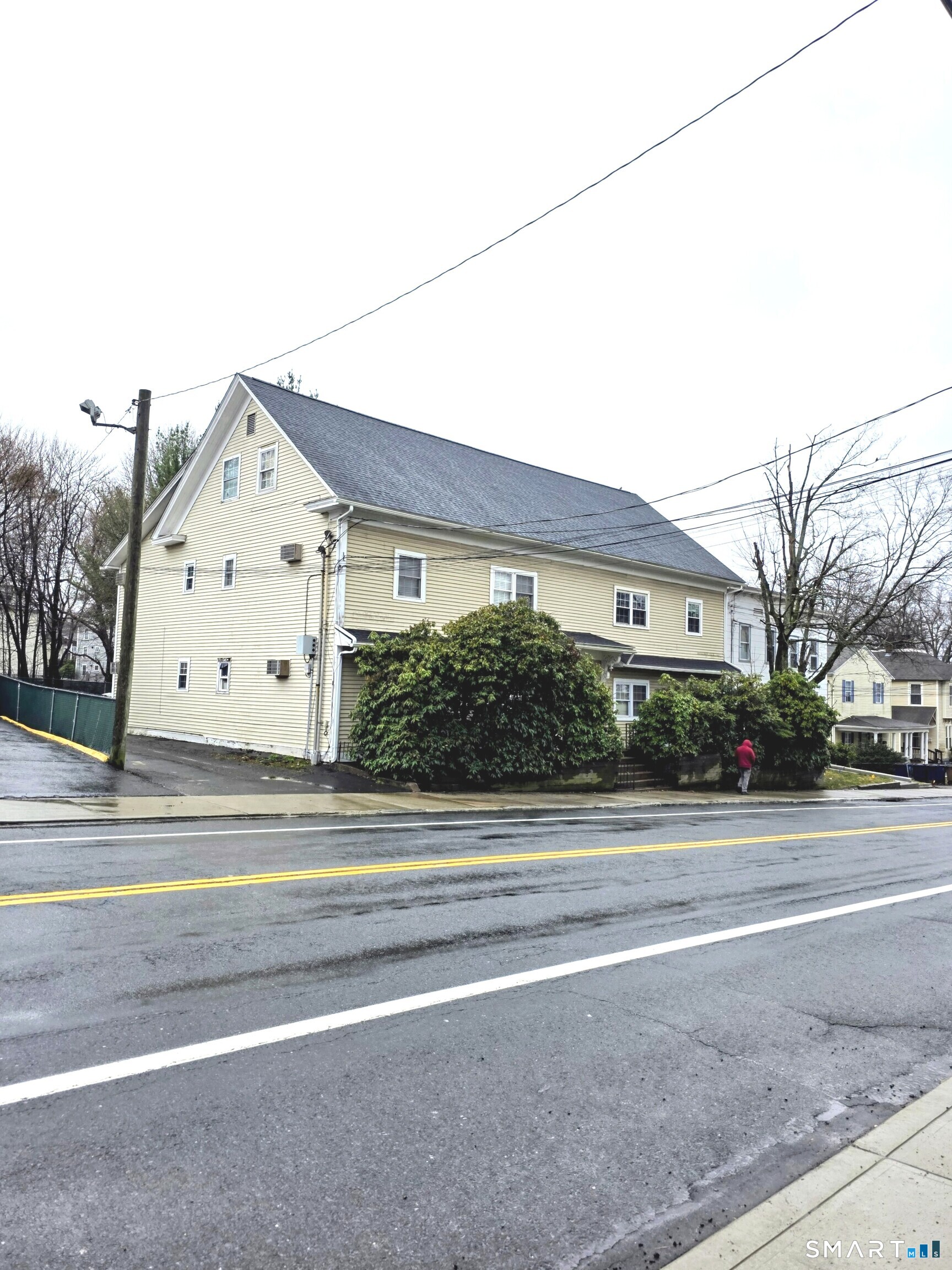 a view of a house with a yard and large parking space