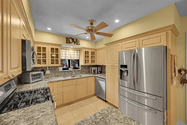 a kitchen with stainless steel appliances granite countertop a refrigerator and a sink