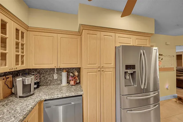 a kitchen with granite countertop stainless steel appliances a refrigerator and counter space