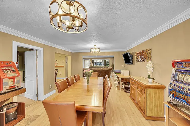 a living room with furniture a dining table and a bookshelf with wooden floor