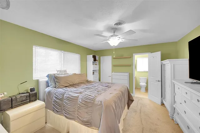 a bedroom with a bed a flat screen tv and dresser