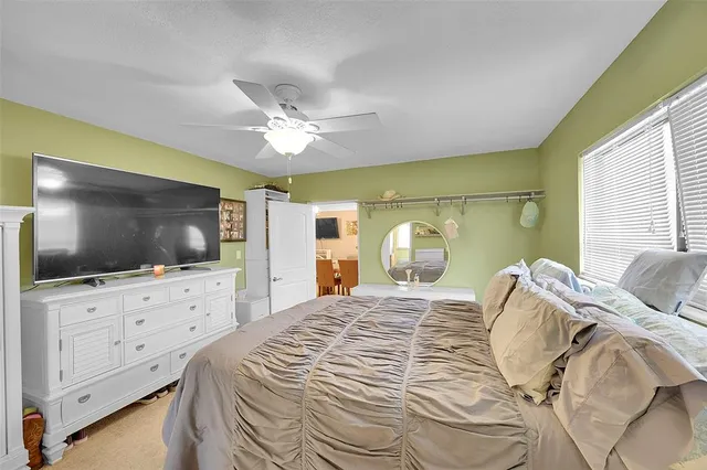 a bedroom with a bed a flat screen tv and dresser with the screen