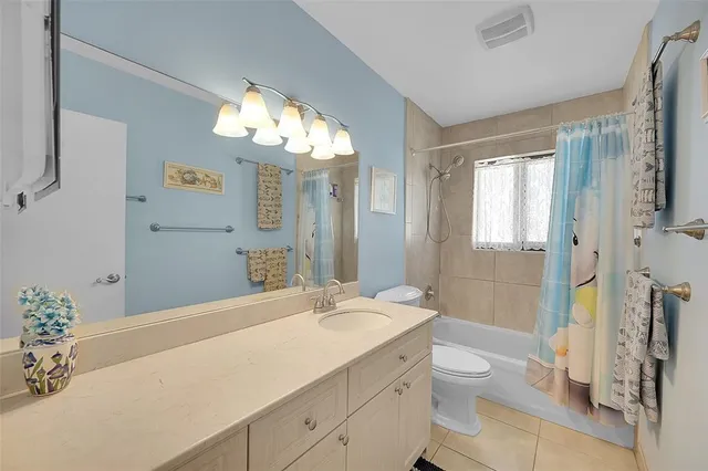 a bathroom with a granite countertop sink toilet a large mirror a shower and a bathtub