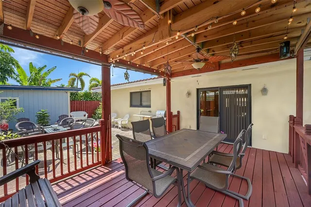 a view of a roof deck with table and chairs with wooden floor
