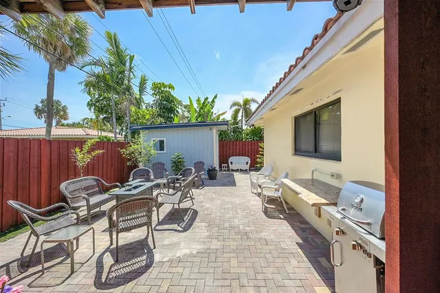 a view of a patio with table and chairs potted plants and wooden fence