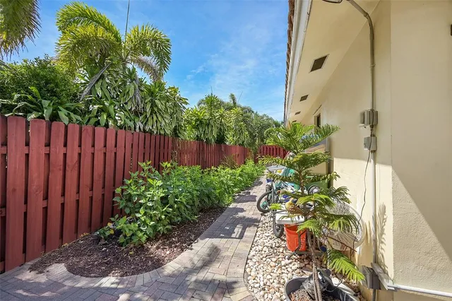 a view of a backyard with potted plants and wooden fence
