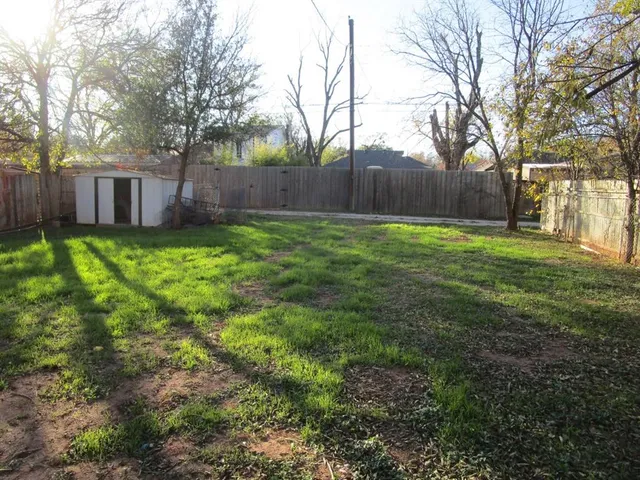 a view of a backyard with large trees
