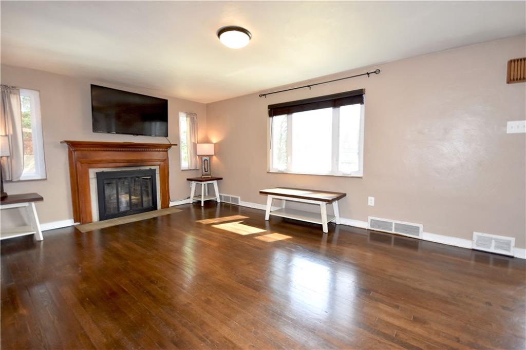 104 Earlwood Road Pittsburgh, PA 15235 - Photo 5 of 40 an empty room with wooden floor fireplace and windows
