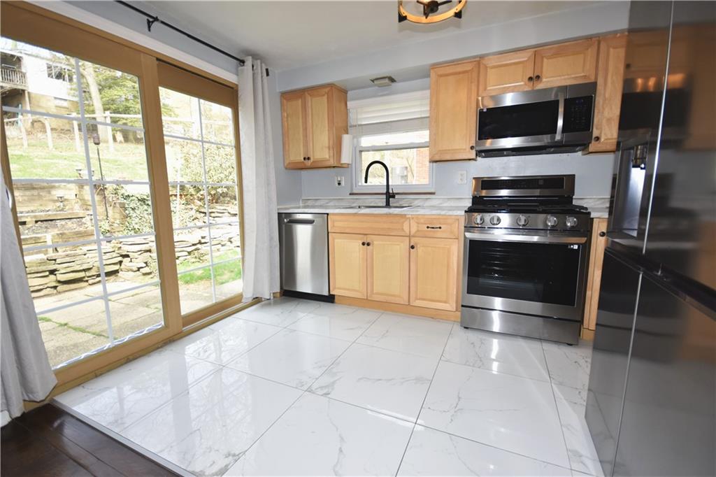 104 Earlwood Road Pittsburgh, PA 15235 - Photo 10 of 40 a kitchen with stainless steel appliances granite countertop a stove a sink and a microwave