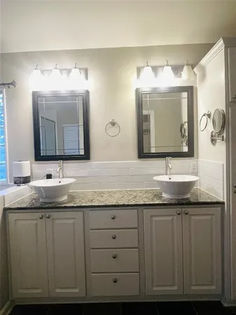 a bathroom with a granite countertop sink vanity and a mirror