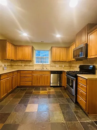 a kitchen with stainless steel appliances granite countertop a stove sink and cabinets