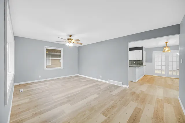 a view of a livingroom with wooden floor and a ceiling fan