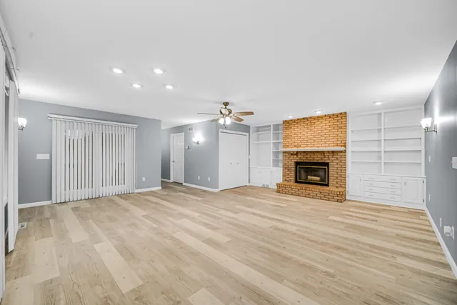 a view of empty room with wooden floor and fireplace