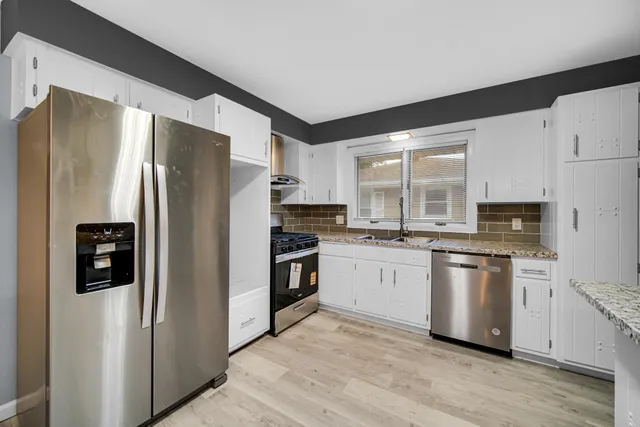 a kitchen with stainless steel appliances a refrigerator sink and microwave