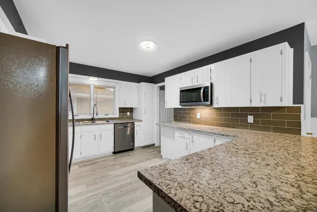a kitchen with granite countertop cabinets stainless steel appliances and a sink