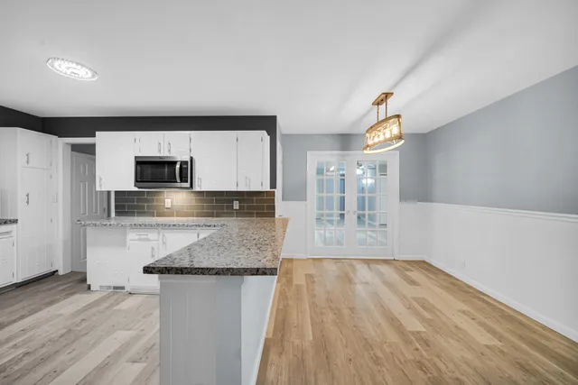 a kitchen with granite countertop a stove and cabinets
