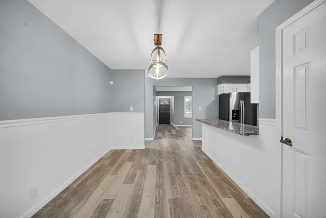 a view of a hallway with wooden floor and staircase
