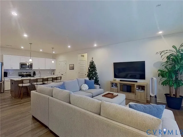 a living room with furniture a flat screen tv and a fireplace