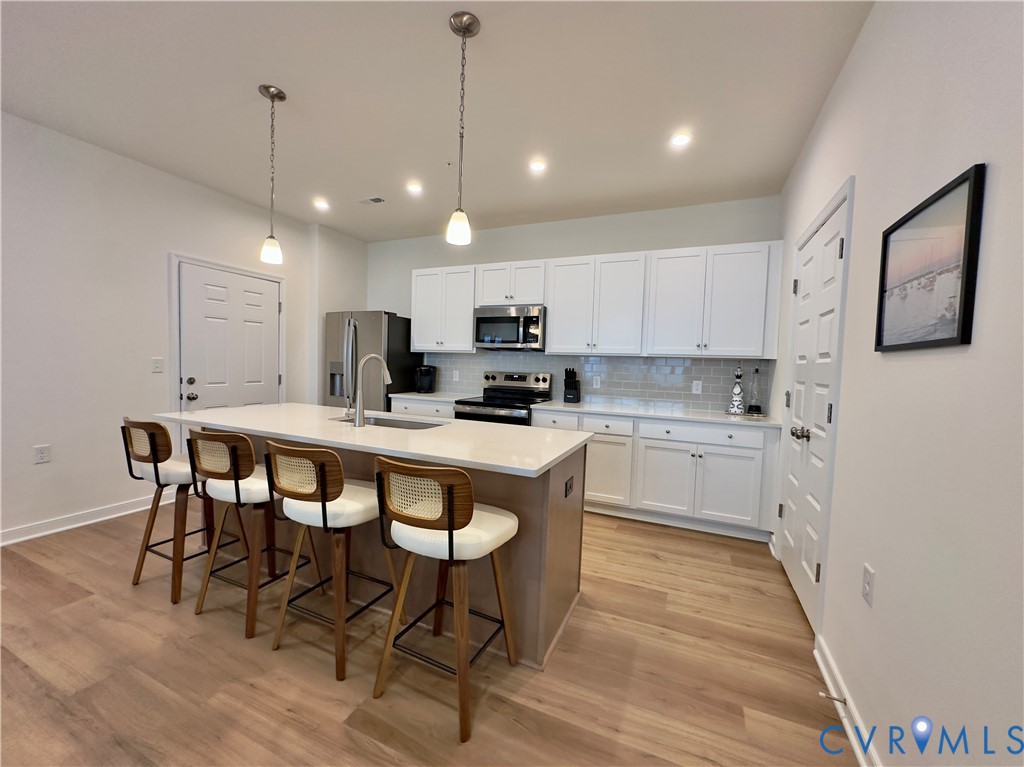 12423 Wescott Avenue Midlothian, VA 23112 - Photo 6 of 25 a kitchen with kitchen island granite countertop a sink a counter space stainless steel appliances and cabinets