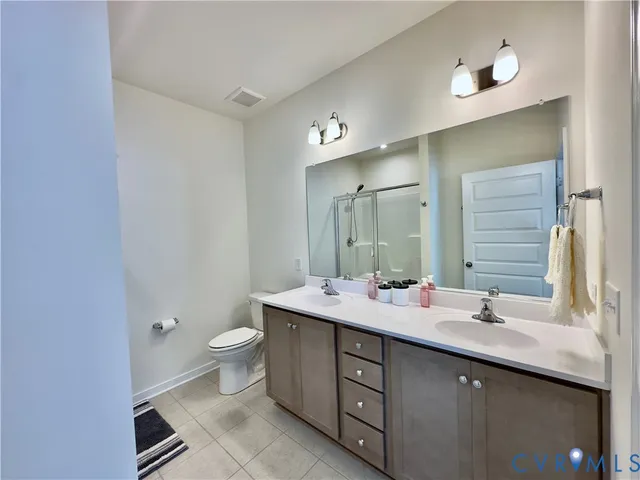 a bathroom with a double vanity sink toilet and a mirror