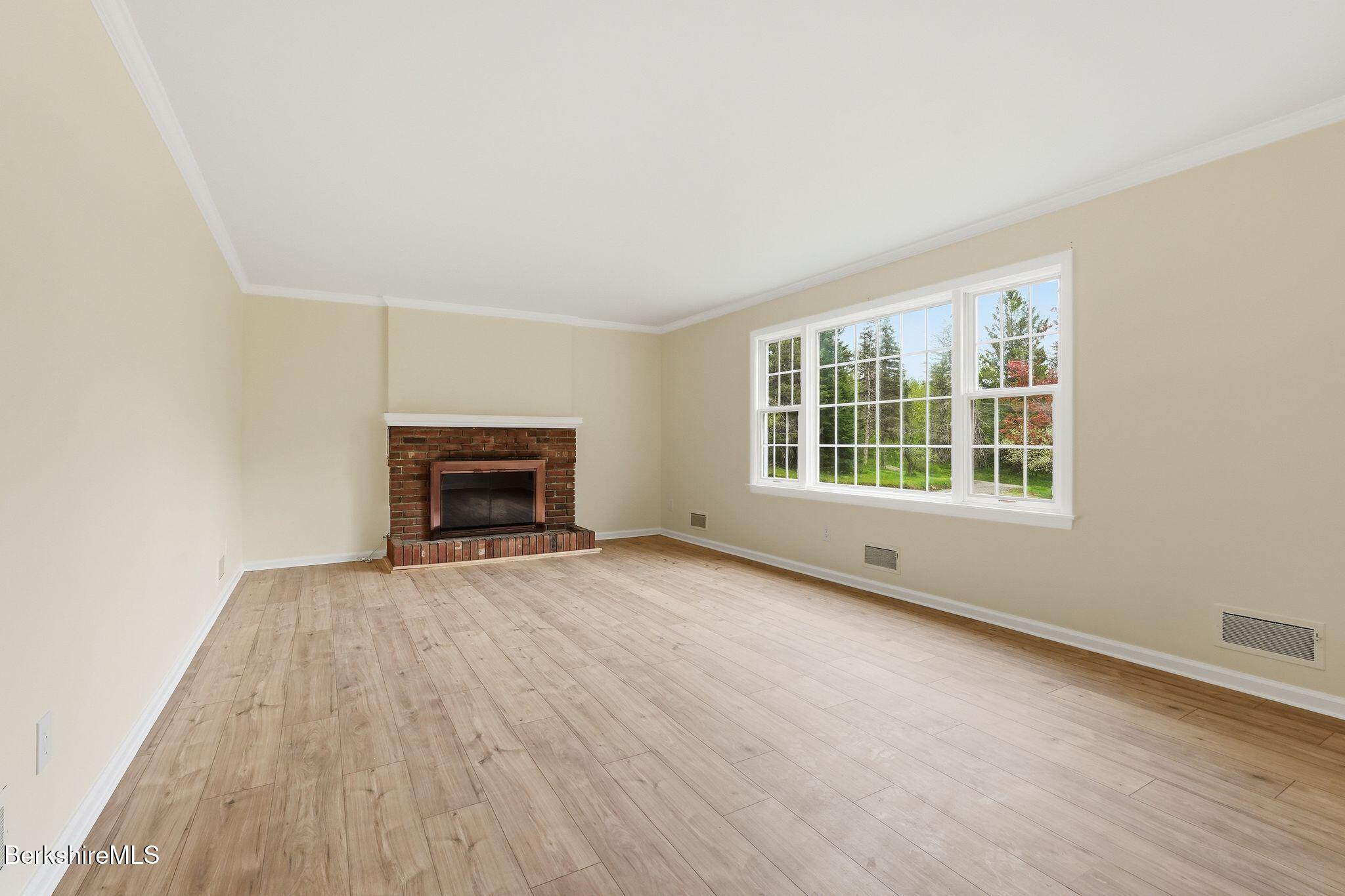 98 N Road Monroe, MA 01247 - Photo 9 of 32 a view of an empty room with wooden floor fireplace and a window