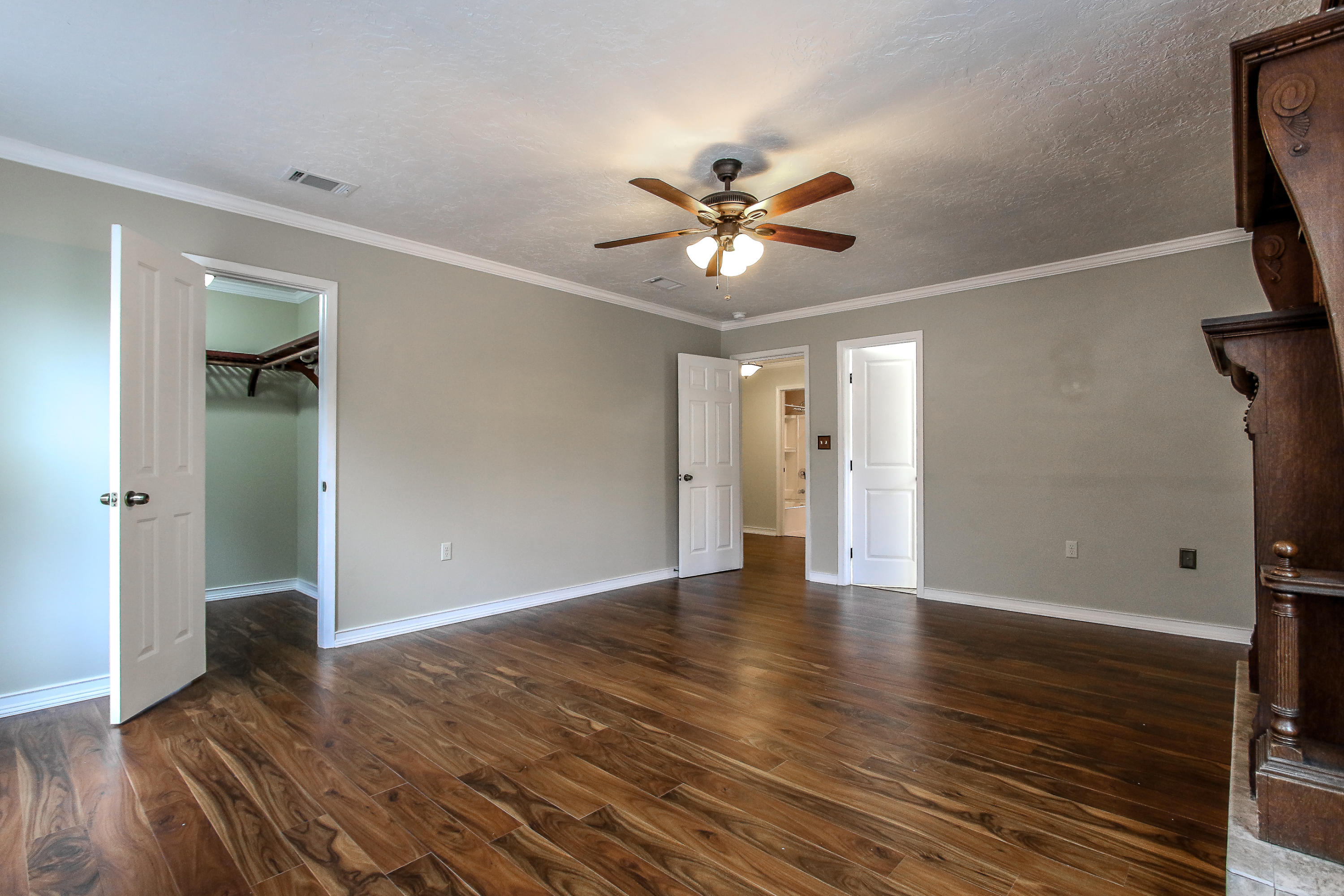 237 Country Club Road Shalimar, FL 32579 - Photo 61 of 74 a view of an empty room with wooden floor and a ceiling fan