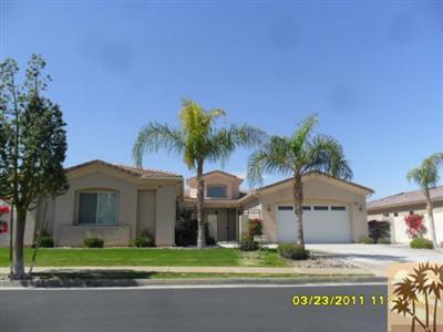 23 Napoleon Road Rancho Mirage, CA 92270 - Photo 1 of 7 a front view of a house with a garden and a tree