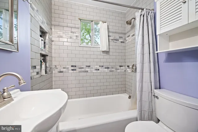 a bathroom with a sink and bathtub with shower