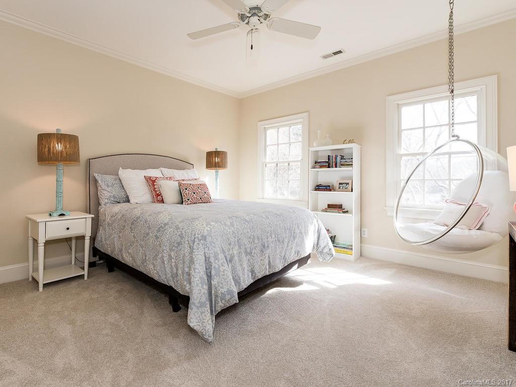 1900 Harris Road Charlotte, NC 28211 - Photo 16 of 24 a bedroom with a bed a table and a chandelier