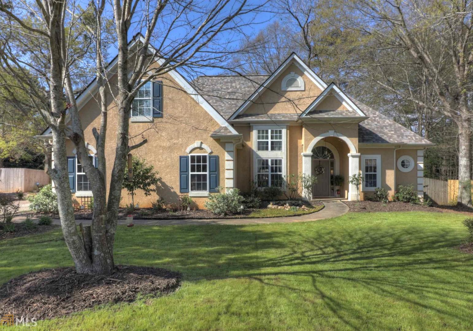 a front view of a house with swimming pool and garden