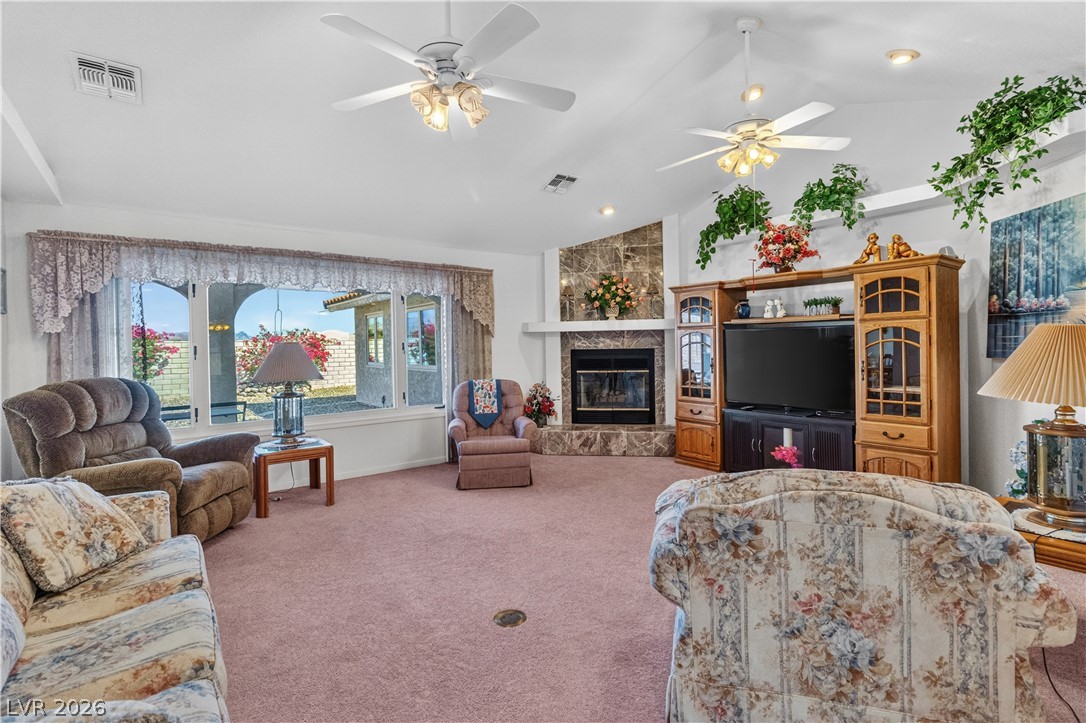 2055 Cholla Way Laughlin, NV 89029 - Photo 6 of 87 A spacious living area offers a cozy fireplace with a marble surround and abundant natural light from wide windows.