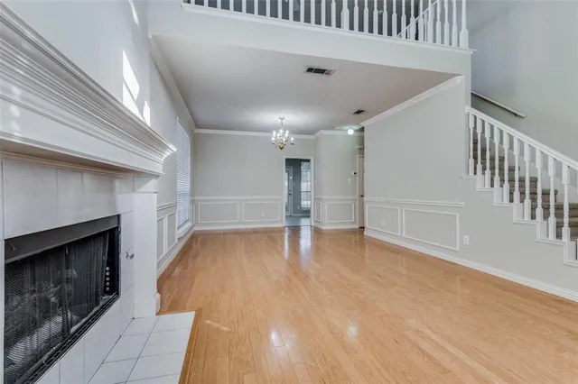 an empty room with wooden floor fireplace and windows