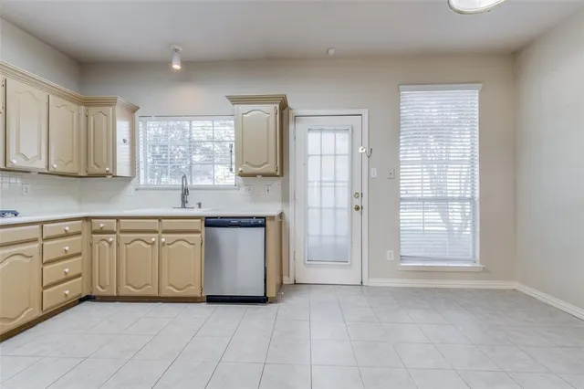 a kitchen with granite countertop white cabinets white stainless steel appliances with a sink and dishwasher